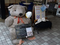  Giant bear and smaller bears in bed. Seems to be a normal way of advertising a restaurant