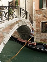  Gondola driver passes under a bridge.